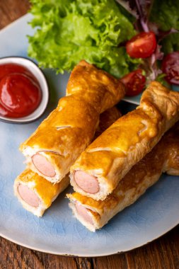 Bir tabakta sosisli börek.