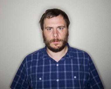 adam bir ifade olmadan sadece kameraya bakıyor