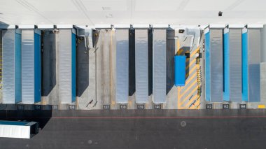 Çok sayıda mavi ve gümüş kamyonlar çok sayıda park halindedir. Kamyonlar sıra sıra park edilmiş, bazıları kameraya daha yakın, diğerleri ise daha uzakta.