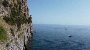 Adriyatik Denizi üzerinde güzel bir manzarası ve mavi suları olan bir uçurumun kenarından geçen gemilerin görüntüleriyle bir uçuş..