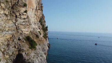 Adriyatik Denizi üzerinde güzel bir manzarası ve mavi suları olan bir uçurumun kenarından geçen gemilerin görüntüleriyle bir uçuş..