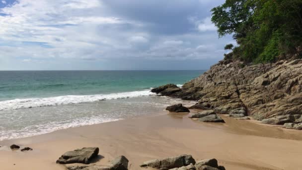 蓝色的大海 平静的海滩隐藏着 有岩石和树木生长 在阳光灿烂的日子 — 图库视频影像