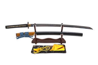 Japon kılıcı ahşap tezgahta beyaz arka planda, siyah ipek çanta standın önünde..