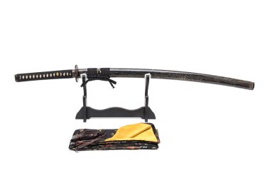 Ahşap standı ve önünde ipek çanta siyah kordon ile sarılmış tam ışın deri ile Japon kılıç, beyaz arka planda izole.