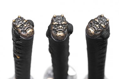 3 views of Kashira : butt cap (or pommel) made of copper on the end of the black silk cord handle  Japanese sword isolated in white background. Devil face style.