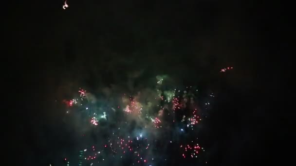 Explosivos y coloridos fuegos artificiales navideños en el cielo nocturno . — Vídeo de stock