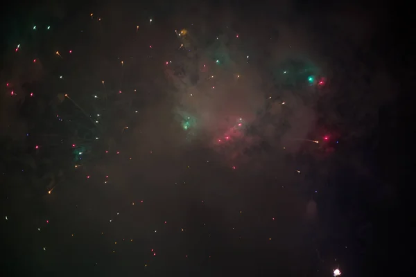 Explosivos y coloridos fuegos artificiales navideños en el cielo nocturno . —  Fotos de Stock