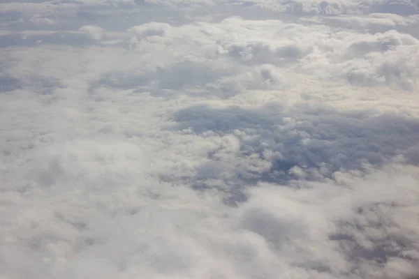 Lufthimmel und flauschige Wolken im Hintergrund. Blick vom Bullauge des Flugzeugs — Stockfoto