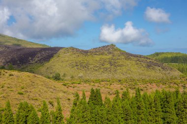 Tepeler tarlaların üzerinde. Mavi gökyüzü ve bulutlarıyla Azores 'teki Terceira Adası.