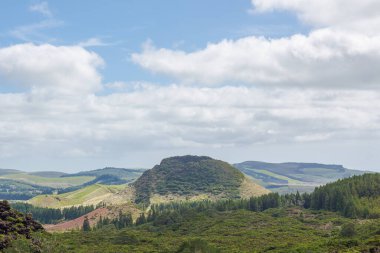 Tepeler tarlaların üzerinde. Mavi gökyüzü ve bulutlarıyla Azores 'teki Terceira Adası.