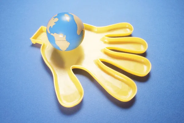 Пластикові Руки Глобусом Синьому Фоні — стокове фото