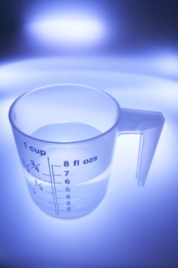 Ölçme kupa mavi arka plan ile plastik