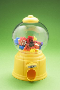 Balonlu sakız makinesi yeşil arka plan ile oyuncak robotlar