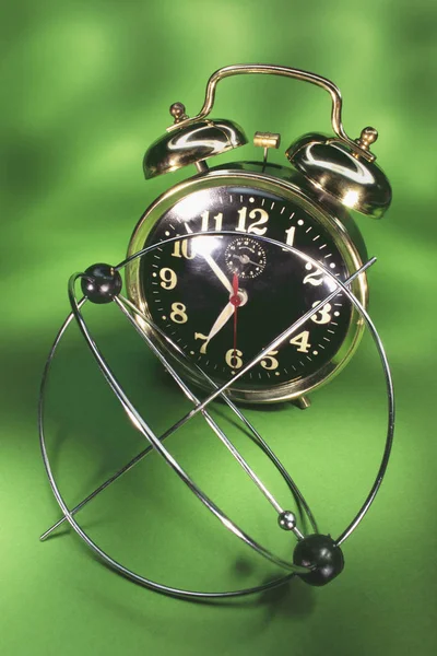 キネティック携帯と緑の背景の目覚まし時計 — ストック写真