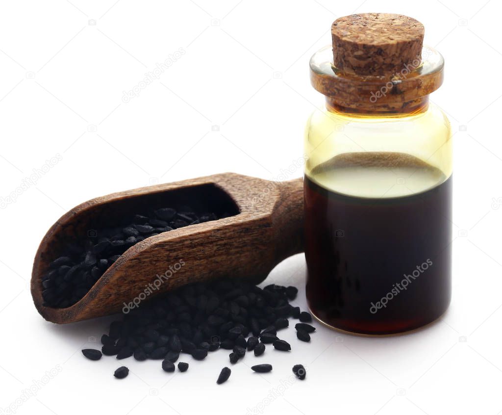 Nigella seeds and essential oil in a glass bottle