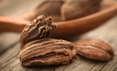 Siyah kakule ahşap yüzey üzerinde tahta kaşıkla tüm