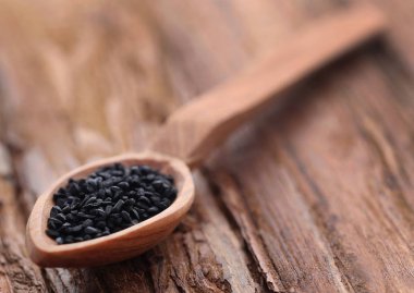 Ahşap ahşap yüzey vurgunun içinde Nigella tohum