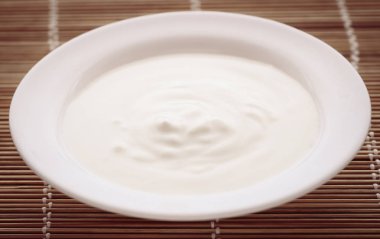 Doğal yüzey üzerinde bir kapta taze yoğurt