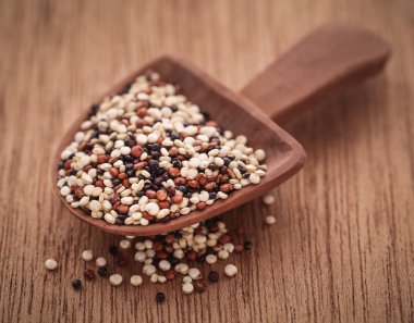 Doğal yüzey üzerinde ahşap kepçe de taze karışık quinoa