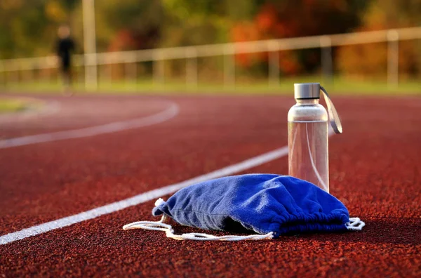 Plecak Butelka Wody Torze Lekkoatletycznego Godzinach Popołudniowych — Zdjęcie stockowe