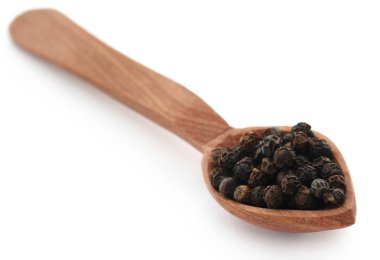 Tahta kaşık üzerinde beyaz arka plan üzerinde siyah biber