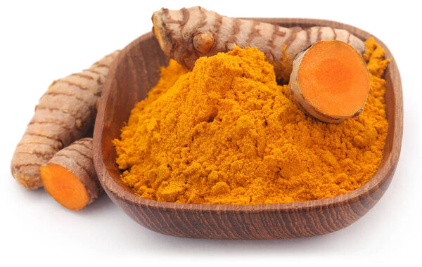 Raw turmeric with powder in a bowl