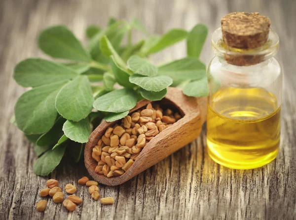 Fenugreek seeds with oil in bottle — Stock Photo, Image