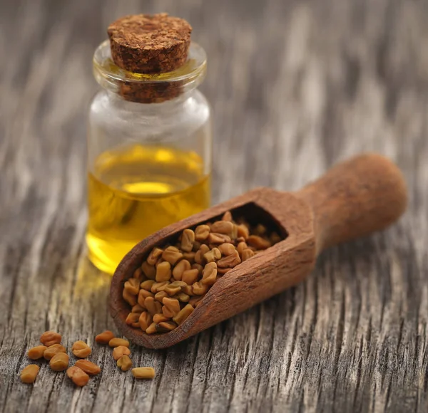 Fenugreek seeds with oil in bottle — Stock Photo, Image