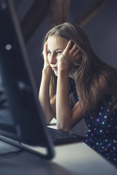 unhappy teenage girl sitting at the computer