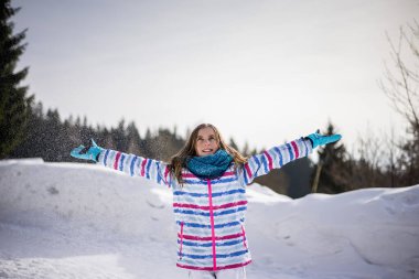 Mutlu genç kız karla oynuyor.  