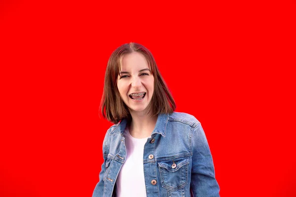 Chica Feliz Con Aparatos Ortopédicos Sobre Fondo Rojo — Foto de Stock