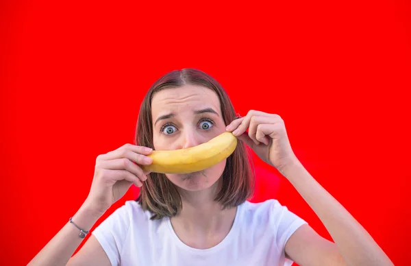 Junges Mädchen Mit Banane Vor Rotem Hintergrund — Stockfoto