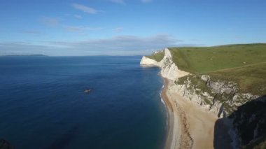Sinek geçmiş ve Durdle kapı Dorset'deki / daki çevresinde açık güneşli bir günde çarpıcı. Uçağı denize yuvarlak ve dışarı geçerken, Jurassic Coast boyunca harika manzaralarına sahip uçurumun üstünde yürüyen bir adam görmek.
