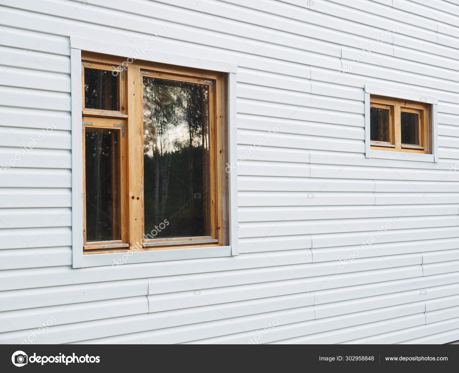 Frame house sheathed in white siding Stock Photo by ©Enskanto 302958848