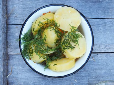 Ahşap bir zeminde, dereotlu patates.