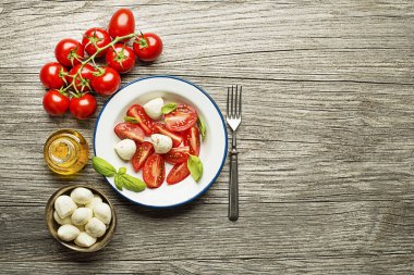 Taze domates ve mozzarella peyniri ahşap arka plan üzerinde. Üstten Görünüm