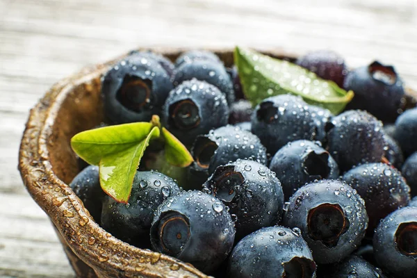 ボウルに葉の新鮮なブルーベリーをクローズ アップ 健康的な食事と栄養の概念 — ストック写真