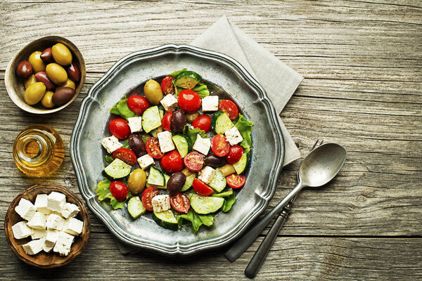 Salad with feta cheese and fresh vegetables on wooden background. Greek salad.