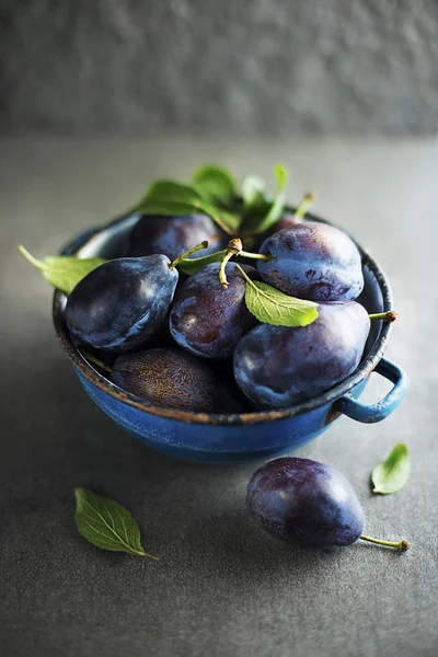 Ciruelas Azules Frescas Con Hojas Mesa Piedra Cerca —  Fotos de Stock