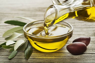 Zeytin ve şube bir cam kase dökme zeytinyağı şişesi