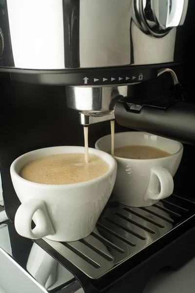 Espresso coffee pouring from coffee machine. Professional coffee brewing