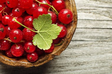 Fresh redcurrant berries on wooden background close up clipart