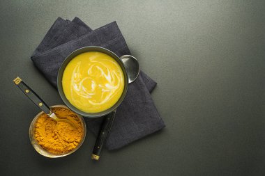 Sağlıklı zerdeçal veya curcuma kremalı çorba siyah arka plan üzerine