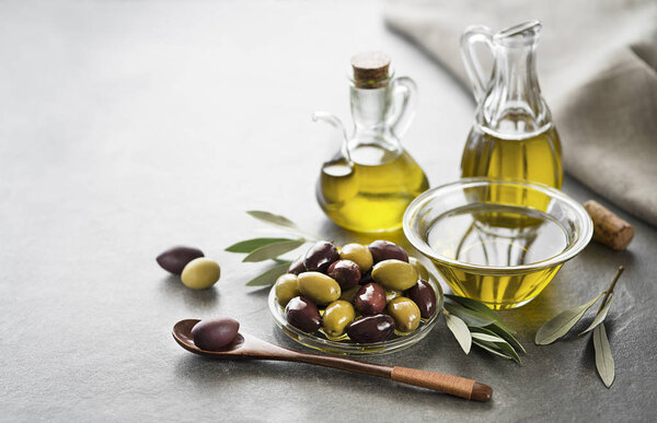 Bottle of Extra virgin healthy Olive oil with fresh olives close up