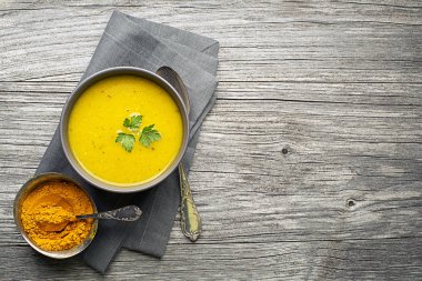 Sağlıklı zerdeçal veya curcuma kremalı çorba ahşap arka plan üzerinde