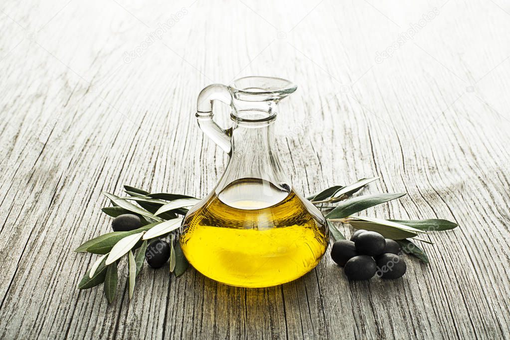 Bottle of Extra virgin healthy Olive oil with fresh olives close up