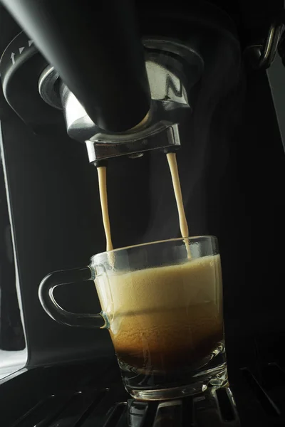 Espresso coffee pouring from coffee machine. Professional coffee brewing