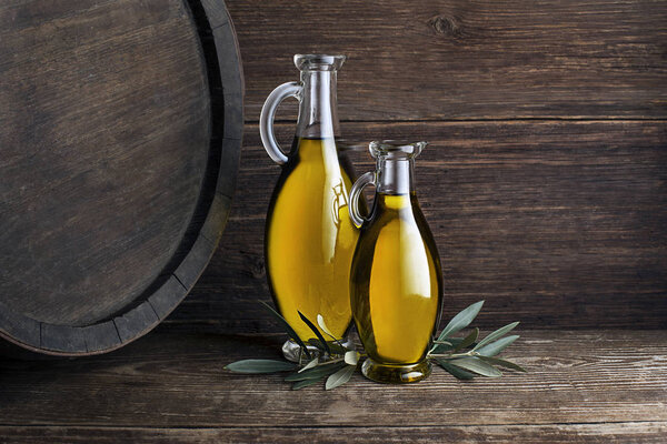 Bottles of Extra virgin healthy Olive oil with barrel background 