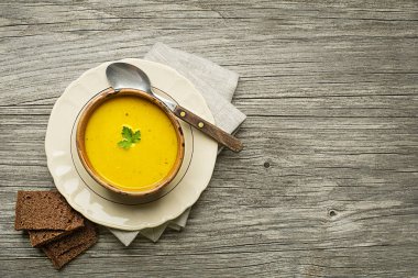 Sağlıklı kabak ve zerdeçal veya curcuma kremalı çorba ahşap arka plan üzerinde