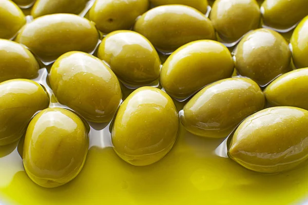 Aceite de oliva con fondo de aceitunas — Foto de Stock
